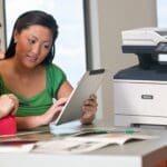 Xerox® VersaLink® B415 Multifunktionsdrucker am Arbeitsplatz Zwei Frauen nutzen ein Tablet vor einem Xerox® VersaLink® B415 Multifunktionsdrucker
